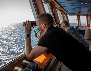 The MSF team scans the horizon in search of a boat in distress. (Geo Barents, September 2021, @Pablo Garrigos)
