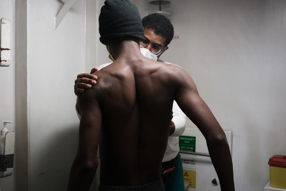 Il medico di MSF visita un sopravvissuto che soffre di dolori al petto. (Geo Barents, marzo 2022, @Kenny Karpov)